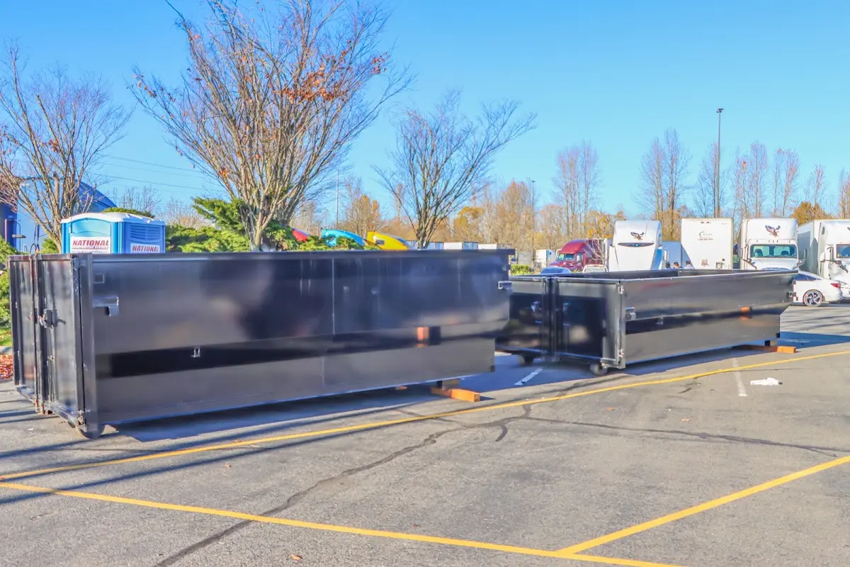 Professional dumpster rental service with roll-off container on residential driveway in Fort Gratiot